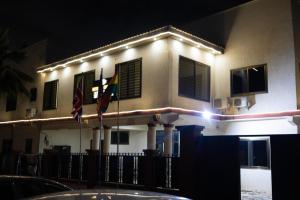 two flags in front of a building at night at Maya Lodge in Accra