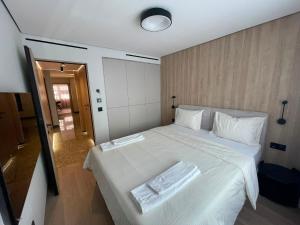 a bedroom with a white bed with two towels on it at Apartament 1 Lalelelor in Năsăud