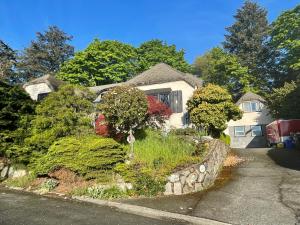 a white house with a stone retaining wall at UVIC Ocean View Private Guesthouse in Victoria +30 photos
