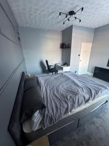 a bedroom with a large bed with a ceiling fan at Ca stays in Heywood