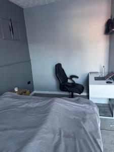 a black chair in a bedroom with a desk at Ca stays in Heywood