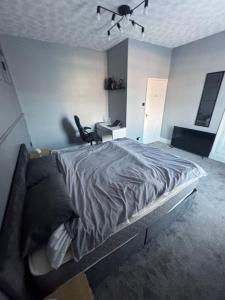 a bedroom with a large bed and a desk at Ca stays in Heywood