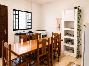 a kitchen with a wooden table and wooden chairs at Casa do Lago in Londrina