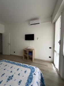 a bedroom with a bed and a tv on a wall at Zuly House in Savona