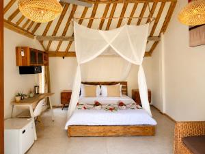 a bedroom with a bed with a mosquito net at Meno Dream Resort in Gili Meno +37 photos