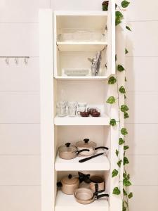 a white pantry with dishes and utensils at Casa do Lago in Londrina +10 photos