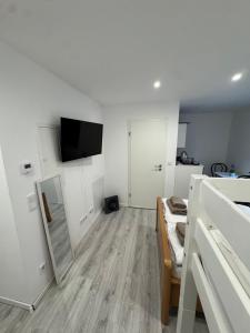 a kitchen with white walls and a wooden floor at Ferienwohnung Manolya in Günzburg