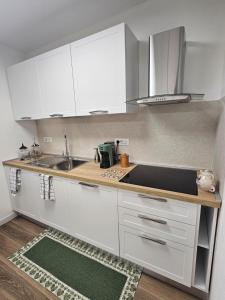 a kitchen with white cabinets and a sink at Casa natura in Usini