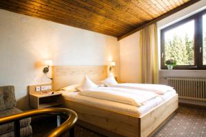 a bedroom with a large bed with a window at Interest Vitalhotel - Partnerbetrieb von Oberstaufen PLUS in Oberstaufen +90 photos