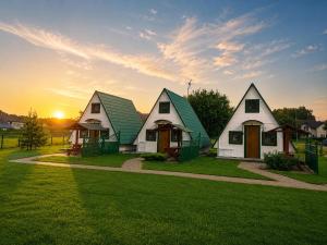 a group of houses with the sunset in the background at Bajeczne domki in Ustka