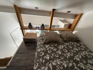 a bedroom with a bed and a shelf on the wall at Petit cocon avec mezzanine in Six-Fours-les-Plages