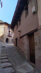 an alley in an old stone building with a door at Casa Les Donfelises in Peñarroya de Tastavins
