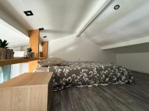 a bedroom with a bed and a wooden floor at Petit cocon avec mezzanine in Six-Fours-les-Plages