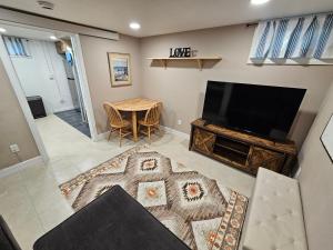 a living room with a television and a table at The Cottonwood Den in Laramie