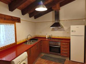 a kitchen with a white refrigerator and a sink at Casa Les Donfelises in Peñarroya de Tastavins
