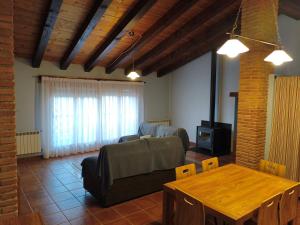 a living room with a couch and a table at Casa Les Donfelises in Peñarroya de Tastavins