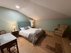 a bedroom with a bed and a chair at Villa Bessa Nature & Spa in Fafe +36 photos