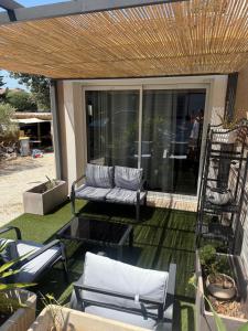 a patio with two chairs and a couch and a table at Petit cocon avec mezzanine in Six-Fours-les-Plages