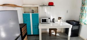 a small kitchen with a white table and a microwave at Joe's Place Self-Catering in Windhoek