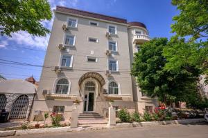 a large gray building with flowers in front of it at Vila Randunica in Eforie Sud