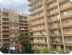 a large apartment building with a hotel sign on it at Adriatic Pearl Apartamets in Lezhë