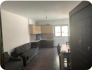 a living room with a couch and a table and a kitchen at Adriatic Pearl Apartamets in Lezhë
