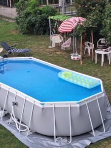 a large pool with aogie board and an umbrella at Apartman ISKRA in Mataruška Banja +15 photos