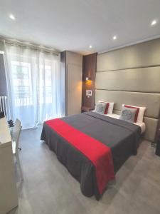 a bedroom with a large bed with a red blanket at Hotel Schtak in Cannes +17 photos