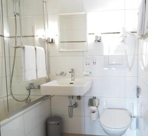 a white bathroom with a sink and a toilet at Hotel Weisses Kreuz in Interlaken +50 photos