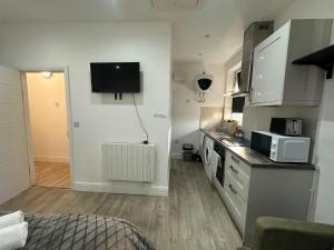 a small kitchen with a sink and a microwave at Wimbledon chase self- catering studio in Raynes Park