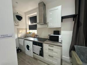 a small kitchen with a sink and a microwave at Wimbledon chase self- catering studio in Raynes Park
