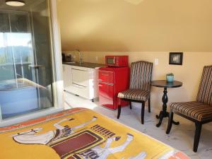 a kitchen with a red refrigerator and two chairs and a table at UVIC Ocean View Private Guesthouse in Victoria