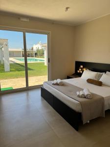 a bedroom with a large bed with towels on it at Cantine De Mare - Wine and Resort in Cirò Marina +55 photos
