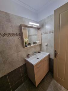 a bathroom with a sink and a mirror at Menelino, next to local bus and airport station in Argostoli +7 photos