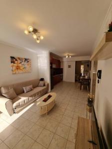 a living room with a couch and a table at Menelino, next to local bus and airport station in Argostoli