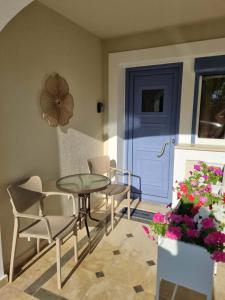 a room with a table and chairs and a blue door at Menelino, next to local bus and airport station in Argostoli