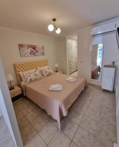 a bedroom with a large bed with two towels on it at Menelino, next to local bus and airport station in Argostoli