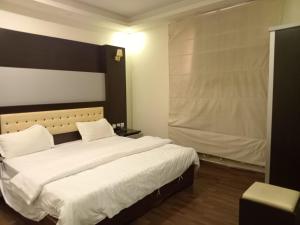 a bedroom with a large bed with white sheets at ستارلت للشقق المخدومة in Buraydah