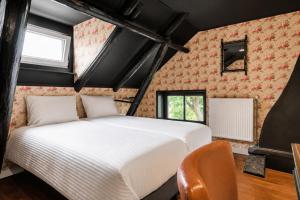 a bedroom with a white bed in a room at Moeke Breughel in Winschoten