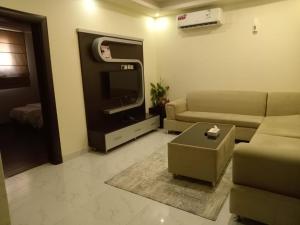 a living room with a couch and a tv at ستارلت للشقق المخدومة in Buraydah
