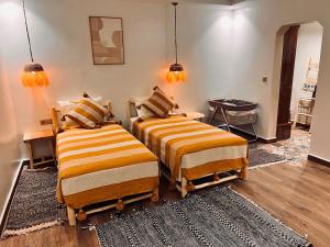 two beds sitting in a room with a rug at Villa TaouBa in Ghazoua +51 photos