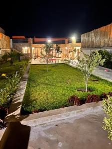 a garden at night with a building in the background at Villa TaouBa in Ghazoua