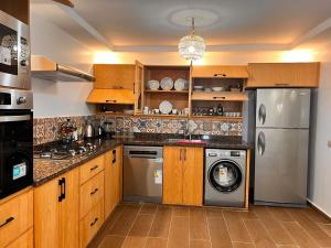 a kitchen with wooden cabinets and a washer and dryer at Villa TaouBa in Ghazoua