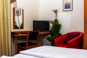 a room with a desk with a computer and a red chair at Suite Hotel 900m zur Oper in Vienna