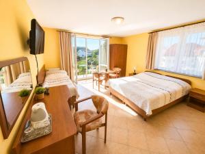 a bedroom with a bed and a desk and a television at Willa Julia in Rewal +24 photos