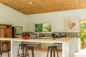 a kitchen with a large island with stools at Selvática Residences in Puerto Viejo