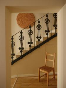 a wooden chair sitting next to a stair case at Casa Reina Cabanyal in Valencia
