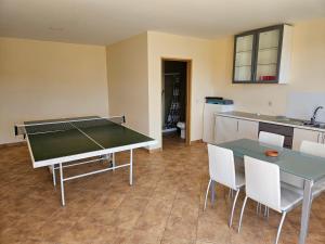 a kitchen with a ping pong table and chairs at Quinta do Penedo- Refúgio de Charme e Natureza in Ferreira do Zêzere