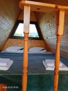 a bed in a wooden cabin with two windows at Akhateli in Ruispiri