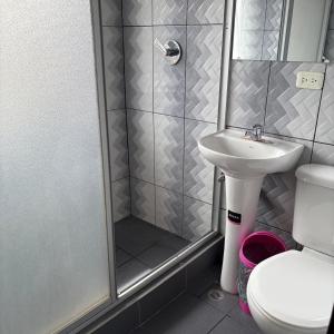 a bathroom with a shower and a toilet and a sink at Hostal Mediodía MATRIZ in Quito